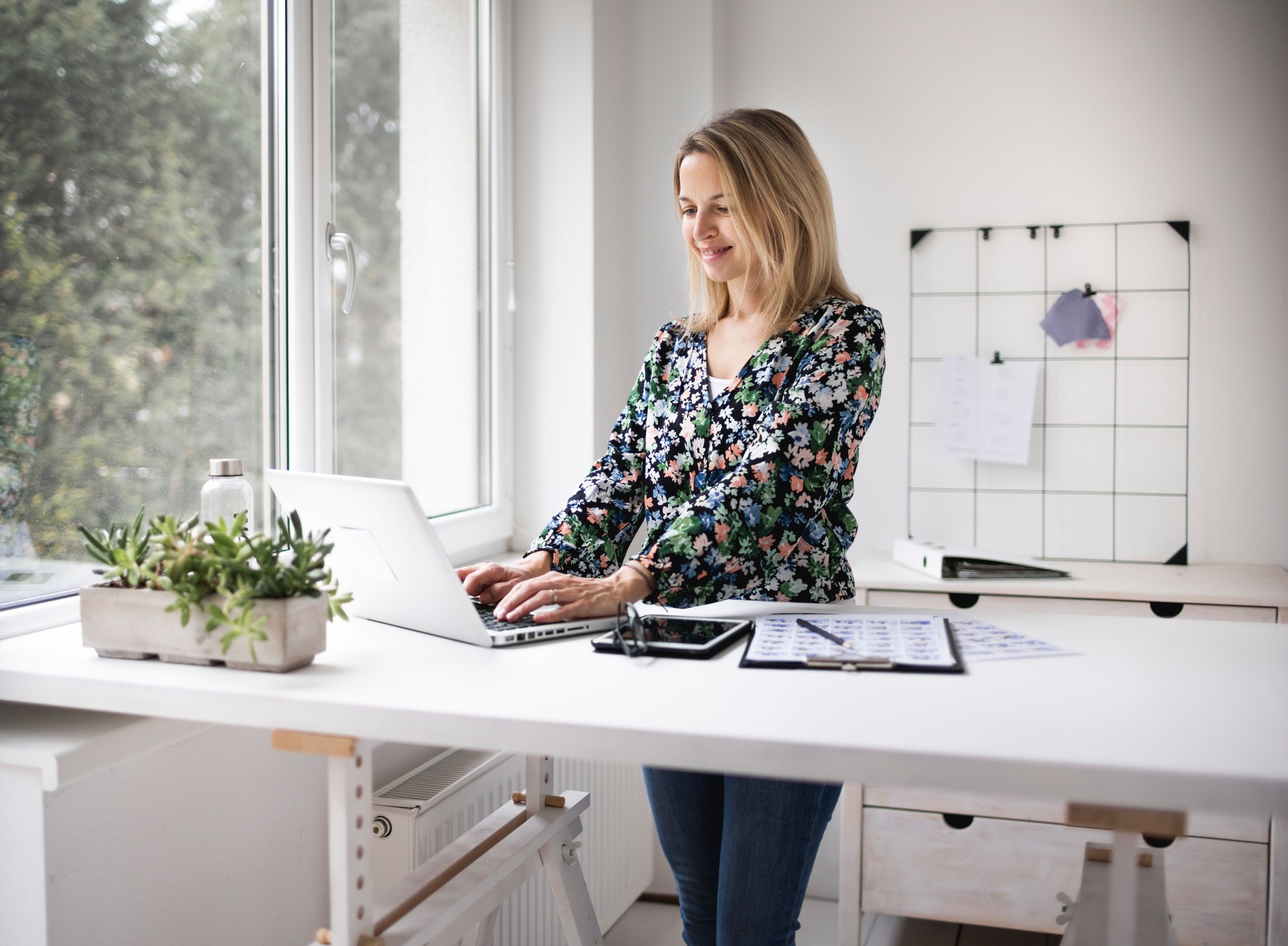 Businesswoman working at ergonomic standing workstation.
